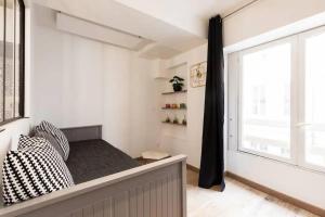 een slaapkamer met een bed en een raam bij Le Flesselles - Hyper centre - Calme et cosy in Lyon