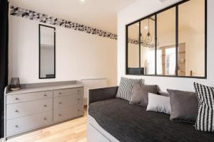 a bedroom with a bed and a dresser with mirrors at Le Flesselles - Hyper centre - Calme et cosy in Lyon