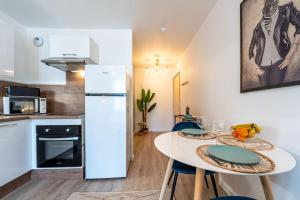 a kitchen with a white refrigerator and a table at Proche Technopole: lit double - fibre - lave-linge in Grenoble