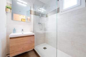 een badkamer met een douche, een wastafel en een spiegel bij Proche Technopole: lit double - fibre - lave-linge in Grenoble