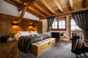 a bedroom with a large bed with a wooden wall at Fer à Cheval in Megève +87 photos