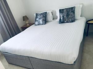 uma grande cama branca com duas almofadas em Smarty Angel em Bournemouth