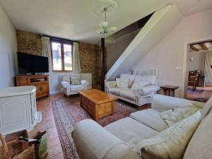 ein Wohnzimmer mit weißen Sofas und einem TV in der Unterkunft Maison Normande - Cosy - Haras du Pin à 30' in Fay