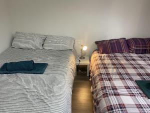 two beds sitting next to each other in a bedroom at Great 5-Bed Wembley Home 25min from Central London in London
