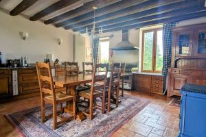 eine große Küche mit einem Holztisch und Stühlen in der Unterkunft Maison Normande - Cosy - Haras du Pin à 30' in Fay