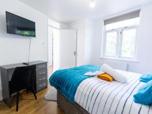 a bedroom with a bed and a flat screen tv at 3 bedrooms House with nice park view in Thamesmead