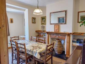 a dining room with a table and a fireplace at Harbour Hill in Chickerell