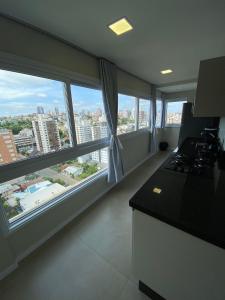 a kitchen with large windows with a view of a city at 4 Apartamentos amplos e novos, 86m e 45m, excelente localização, garagem, 350Mb de internet in Bento Gonçalves