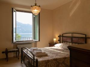 a bedroom with a bed and a large window at Villa Roberta in Mandello del Lario