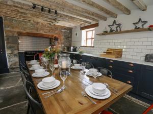 a long wooden table with plates and wine glasses at Nanthir House in Llandrindod Wells