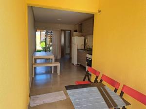 une cuisine avec une table à manger et un mur jaune dans l'établissement Charmoso apto villamares, à Luis Correia