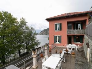 a house with a balcony with a view of the water at Villa Roberta in Mandello del Lario