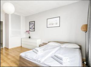a white bedroom with a bed with white sheets at Labo Apartment Niska by Old Town in Warsaw