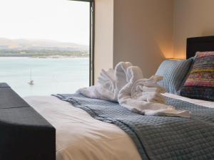Un dormitorio con una cama con una toalla. en Tan Y Fford en Bangor