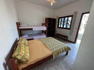 a bedroom with a bed and two bunk beds at POUSADA SOLAR DE ANITA in Garopaba