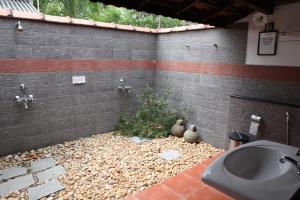 ein Bad mit einem Waschbecken und einem WC in einem Zimmer in der Unterkunft Gramam Homestay, Cochin in Kochi
