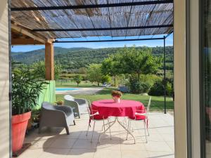 una mesa y sillas en un patio con vistas en Le petit Ventoux en Malaucène