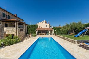 a pool in front of a house with a slide at Villa Vial in Labinci