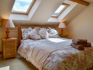 a bedroom with a bed with pillows and two lamps at Binbrook House Mews in binbrook