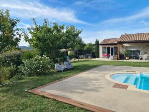 a backyard with a swimming pool and a house at Le petit Ventoux in Malaucène