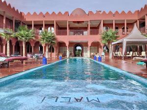 ein großer Pool in einem Innenhof mit einem Gebäude in der Unterkunft Dar De Santis in Azemmour