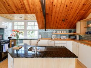 een keuken met een wastafel en houten plafonds bij Hepple Hill Cottage in Consett