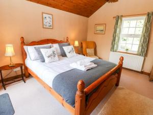 een slaapkamer met een groot houten bed in een kamer bij Hepple Hill Cottage in Consett