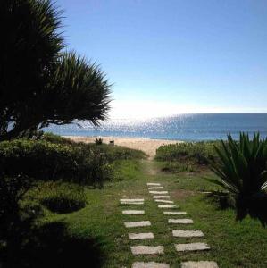 un camino que conduce a una playa con el océano en Casa pé na areia em praia paradisíaca en Balneário Camboriú