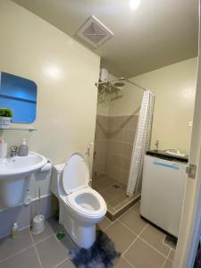 een badkamer met een toilet en een wastafel bij Nalag-an Suite w/ city view BGC in Manilla