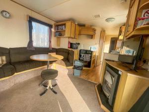 a living room with a couch and a table and a tv at 8 Berth Caravan At California Cliffs By Scratby Beach In Norfolk Ref 50001d in Great Yarmouth