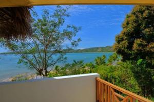 a balcony with a view of the water at ANJARA LODGE Villa de 3 chambres in Nosy Be