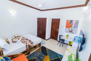 a room with a bed and a table at Shikamoo Spacious Studio Nyali in Mombasa