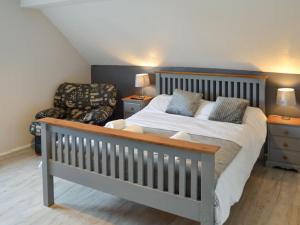 a bedroom with a large bed and a chair at Davids Island in Wroxham