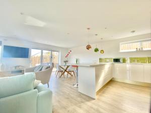 a kitchen and living room with a table and chairs at Little Croft in Holywell Bay