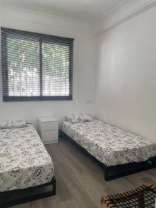 two beds in a white room with a window at Holiday home Salou in Salou