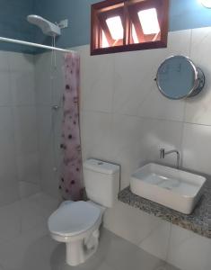 uma casa de banho com um WC, um lavatório e um espelho. em Studios da ilha praia do Francês na Praia do Francês