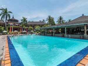 a large blue swimming pool in a resort at Suite Bedroom Legian by DHMhotelier in Seminyak