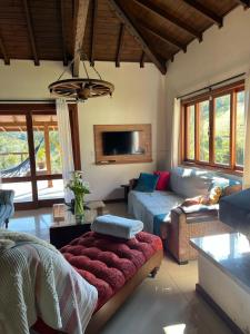 ein Wohnzimmer mit einem Sofa und einem TV in der Unterkunft Quinta da Serra - Onde o charme se mistura com a natureza in Rancho Queimado