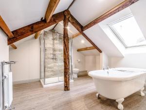 a bathroom with a white bath tub and a window at Ghyll View in Gunnerside