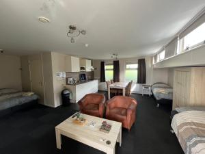 Habitación de hotel con cama y sala de estar. en VVP Verhuur - Visserslust, en Vinkeveen