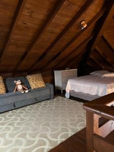 ein Schlafzimmer mit 2 Betten und einem Teddybär auf einer Couch in der Unterkunft Quinta da Serra - Onde o charme se mistura com a natureza in Rancho Queimado