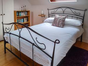 a bed with a black frame and white sheets and pillows at Elm Loft in Upton