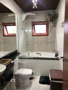 ein Badezimmer mit einer Badewanne, einem WC und einem Waschbecken in der Unterkunft Quinta da Serra - Onde o charme se mistura com a natureza in Rancho Queimado