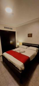 una camera da letto con un grande letto con una coperta rossa di Tamrah Suites Hotel ad Amman