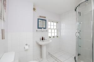 a white bathroom with a sink and a shower at Olive Tale in Henley on Thames
