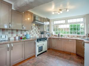 a kitchen with wooden cabinets and a stove top oven at Tanglewood in Bugle