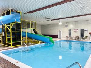 a pool with a water slide in a building at Camp Inn Lodge in Au Sable