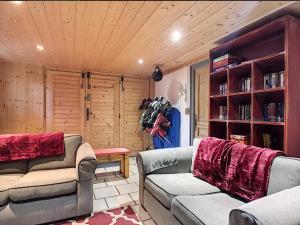a living room with two couches and a book shelf at Chalet Les Gets, 8 pièces, 12 personnes - FR-1-671-141 in Les Gets
