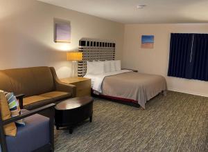 a hotel room with a bed and a couch at Camp Inn Lodge in Au Sable