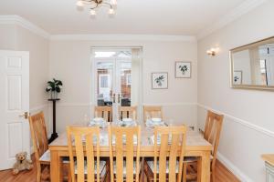 uma sala de jantar com uma mesa de madeira e cadeiras em Olive Tale em Henley on Thames